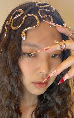 a woman with her hands on her face wearing rings and bracelets over her head