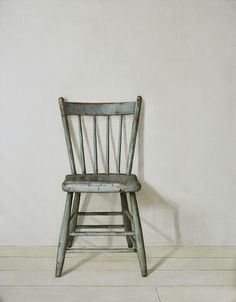 an old wooden chair against a white wall