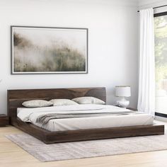 a large bed sitting in a bedroom on top of a hard wood floor next to a window