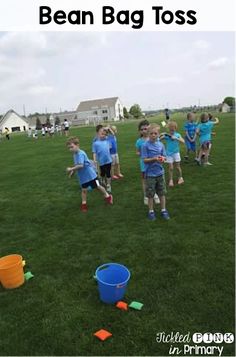 a group of children playing in the grass with plastic cups and buckets on it