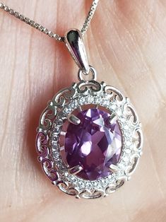 Stunning Alexandrite Rococo Sterling Necklace. 8x10mm Premium Synthetic Color Change Gem. 925 Sterling Necklace with Crystal Accents and Chain. Gift Box Included. Great Gift! Classic Purple Necklace For Gift, Oval Necklace With Halo Setting As Gift, Oval Halo Setting Necklace As Gift, Oval Halo Setting Necklace For Gift, Silver Necklace With Oval Pendant In Halo Setting, Anniversary Oval Pendant Necklace Stamped 925, Elegant Purple Necklace Stamped 925, Natural Opal Ring, Sterling Necklace