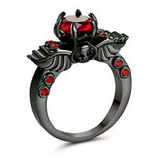 Brand New 18kt Red Ruby Black Gold Skull Wings Ring. Reviving And Epic, This High Fashion Classic Winged Skull Ruby Solitaire Engagement Ring Evokes Character And Elegance Making This Designer Jewelry Piece An Excellent Engagement Ring, Wedding Ring Or A Great Gift You Can Buy For Yourself. Stone Settings In Pave, Prongs, Bezel, Channel Or Invisible May Differ Slightly As The Stones Are Set By Hand. Punk Black Ring For Halloween, Black Punk Rings For Halloween, Punk Black Rings For Halloween, Punk Style Black Skull Ring Gift, Edgy Halloween Rings For Gift, Black Skull Ring For Halloween, Gothic Black Skull Ring For Halloween, Halloween Black Skull Ring, Edgy Skull Ring Gift