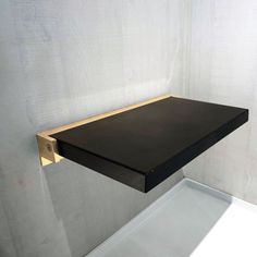 a black shelf sitting on top of a white wall