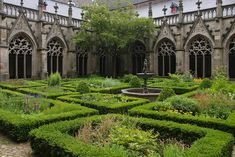 the courtyard of an old building with many hedges