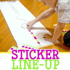 a young boy is making a sticker line - up on a piece of paper