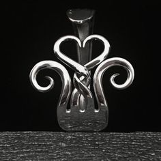 a glass vase with two hearts in the shape of an x on it's side