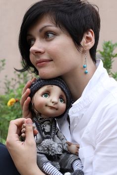 a woman holding a doll in her arms