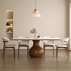 a dining room table with chairs and a vase on it's centerpiece in front of a white wall