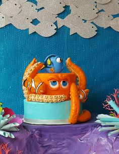 there is a cake with an octopus on it and some decorations around the cake in the background