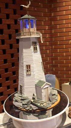 a small white lighthouse sitting on top of a table