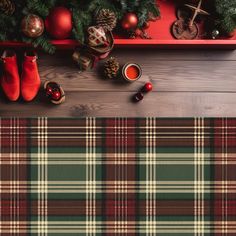 a plaid table cloth with christmas decorations on it and red boots next to the table