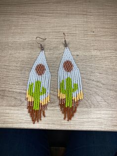 These cute western style earrings are hand beaded to make a cactus shape in the tassels and a moon in the upper triangle. Made with quality glass seed beads  and rustic copper earwires (can be switched with either silver plated or gold plated just send me a message beforehand) . These boho / western style will bring a poke 🌵 of fun to your next outfit! Handmade Southwestern Green Beaded Earrings, Handmade Southwestern Green Earrings, Rustic Beaded Dangle Jewelry, Southwestern Green Beaded Dangling Earrings, Southwestern Green Beaded Dangle Earrings, Southwestern Green Earrings With Dangling Beads, Southwestern Brown Dangle Beaded Earrings, Handmade Rustic Green Earrings, Rustic Handmade Green Earrings