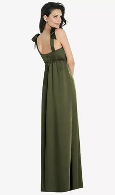 a woman in a long green dress looking back at the camera with her hand on her hip