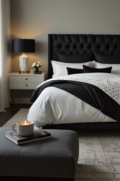 a black and white bedroom with a coffee cup on the footboard next to the bed