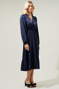 Don't tell us it's just a crush; we're absolutely falling for the Fabiola Split Neck Midi Dress. Sleek woven fabric, with a luxe satin-y, shapes a split neckline and long sleeves with elastic cuffs and the end. It features a high waist top and a flowy midi skirt with a bottom tier and the end. This dress is perfect for your next date night or evening event. - Puffed sleeves- Lined- Pleated- Elastic waist- Comes in 2 colorsSize + Fit - Model is 5'8" and wearing size XS- Measurements taken from si Navy Long Sleeve Midi Dress For Formal Occasions, Elegant Navy Midi Dress For Fall, Elegant Navy Dress For Fall, Elegant Navy Dresses For Fall, Navy Long Sleeve Midi Dress For Party, Chic Navy Long Sleeve Midi Dress, Chic Long Sleeve Navy Midi Dress, Navy Midi Dress For Fall, Flowy Midi Skirt