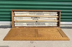 an old wooden box filled with newspapers sitting in front of a green wall