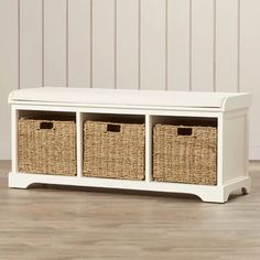 a white bench with wicker baskets on the top and bottom drawers in front of it