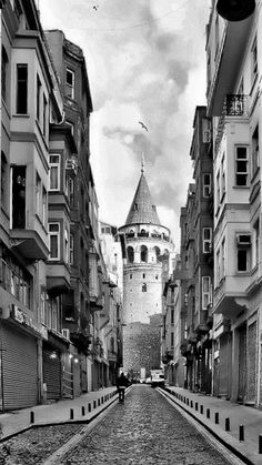 a black and white photo of a cobblestone street in an old european city