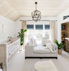 a living room filled with furniture and a baby crib