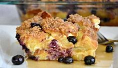 a close up of a plate of food with blueberries and crumbs on it