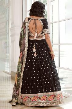 Featured here is a reimagined black georgette lehenga set adorned with bootis and a heavy border showcasing multi-colour thread work both on the lehenga as well as the statement blouse. It is paired with a matching printed floral dupatta with a scalloped border. Style Tip: Finish the look with a kundan polki mala and understated ethnic wedges. Fabric / Material :Georgette Colour: Black Wash Care :Dry Clean Only Please note: Note:- Originally Stitched in 40 & 42 but can alter for size 38 & 40 wit Black Sharara For Reception During Navratri, Black Choli With Intricate Embroidery In Georgette, Black Dress With Mirror Work For Navratri, Black Anarkali Sharara For Reception, Black Sharara With Intricate Embroidery For Reception, Floor-length Black Sharara For Reception, Black Floor-length Party Wear Sets, Embroidered Black Anarkali Party Wear Set, Black Embroidered Anarkali Set For Party