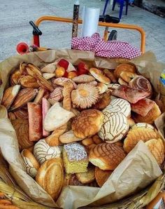 a basket filled with lots of different types of pastries on top of a table