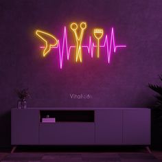 a neon sign that says vitrax on the wall next to a purple cabinet