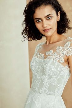 a woman in a white dress posing for the camera