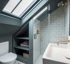 a white toilet sitting next to a bathroom sink under a skylight in a bathroom