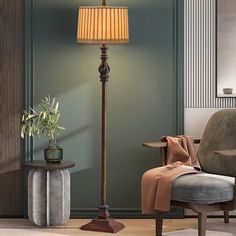 a living room scene with focus on the floor lamp, chair and potted plant