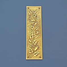 a gold plate with flowers on it against a blue background and the bottom part of the frame