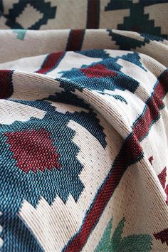 a close up view of a multicolored rug with red, blue and green designs