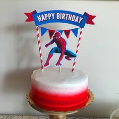 a spiderman birthday cake with red, white and blue frosting on it's top