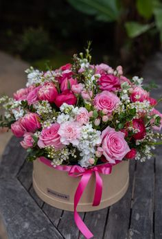 a bouquet of pink roses and white flowers in a box