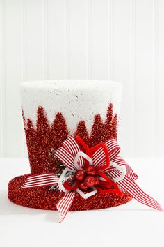 a red and white top hat decorated with candy canes, bows and glitter ribbon