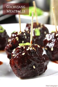 some food is sitting on a plate with toothpicks sticking out of the meatballs