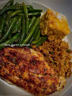 a white plate topped with meat, rice and green beans