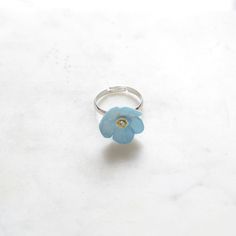 Beautiful porcelain forget me not ring is hand painted and embellished with Swarovski crystal detail.  Each piece is unique and hand finished. Flower size: L2xW2xH0.8 cm. Weight: 10 grams.  Ring is silver plated and adjustable size.  They looks so special when stack them with ladybird or butterfly ring from the same range. Great for everyday wear for both yourself and your loved one. Jewellery Care: Our jewellery is made from porcelain and should be treated as fragile. We recommend that customers should always remove your jewellery when applying scent, lotions and potions, or even better, always put your jewellery on last when getting dressed. Please note that chlorine is especially damaging to jewellery. Ensure that you rinse off any chemicals that come into contact with your jewellery st Forget Me Not Ring, Porcelain Earrings, Ring Flower, Butterfly Ring, Butterfly Jewelry, Stacked Jewelry, Cute Rings, Ceramic Flowers, Forget Me Not