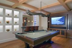 a pool table in front of a flat screen tv