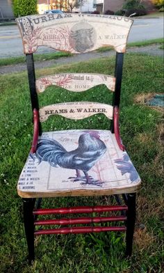 an old chair painted with roosters and water on the back is sitting in grass