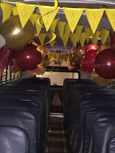 balloons and streamers are hanging from the ceiling in this school bus decorated for graduation