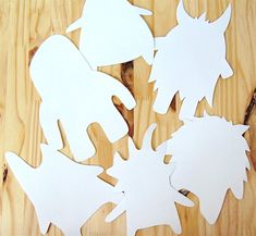 several cut out pieces of paper sitting on top of a wooden table