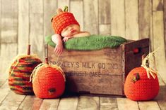 a baby sleeping on top of a wooden crate with three pumpkins around it and the words honey's milk go