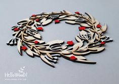 a wooden wreath with red berries and leaves