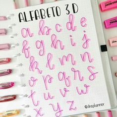 a notebook with pink writing on it next to some markers and marker pens that read, alfareto 3d