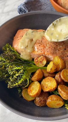 a plate with potatoes, broccoli and salmon on it