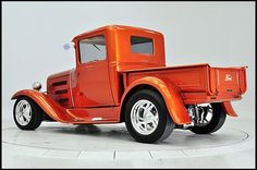 an orange truck parked on top of a white floor