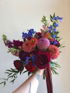 a woman's hand holding a bouquet of flowers