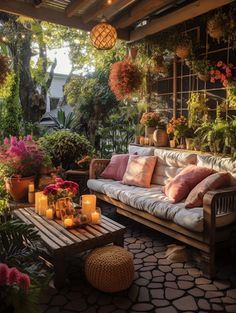 an outdoor living room with lots of plants and candles