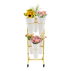 three white vases are stacked on top of each other, with flowers in them